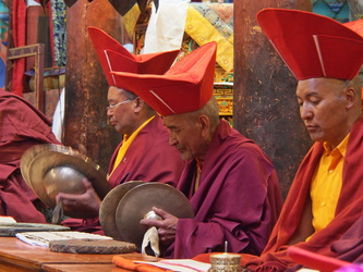 Am Ende der Zeremonie setzen die älteren Mönche ihre Rotmützen auf