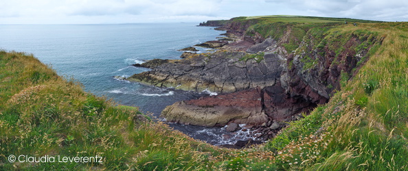 Steilküste mit farbigen Gesteinsschichten