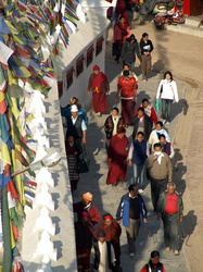 Gläubige umrunden die Stupa und drehen eifrig die vielen Gebetsmühlen